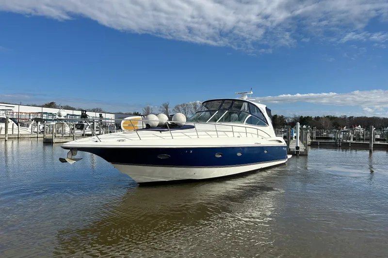 Slide: The Image of 2005 Cruisers Yachts 440 Express in marina, blue and white hull, clear sky. - 10
