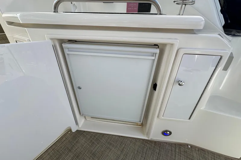 Slide: The Image of 2005 Cruisers Yachts 440 Express interior with open cabinet and built-in refrigerator. - 19