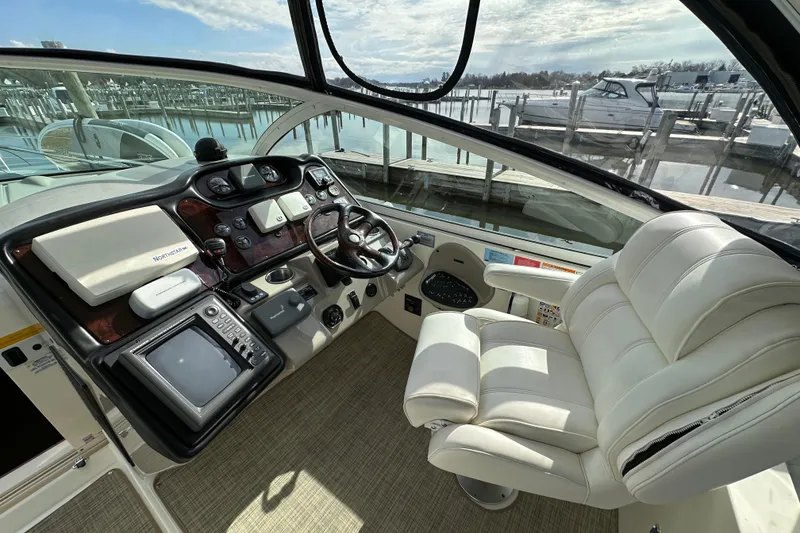 Slide: The Image of 2005 Cruisers Yachts 440 Express helm with luxurious seating and advanced navigation controls. - 21
