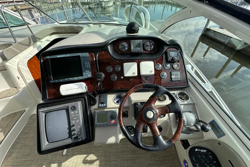 Slide: The Image of 2005 Cruisers Yachts 440 Express helm with navigation instruments and steering wheel. - 22