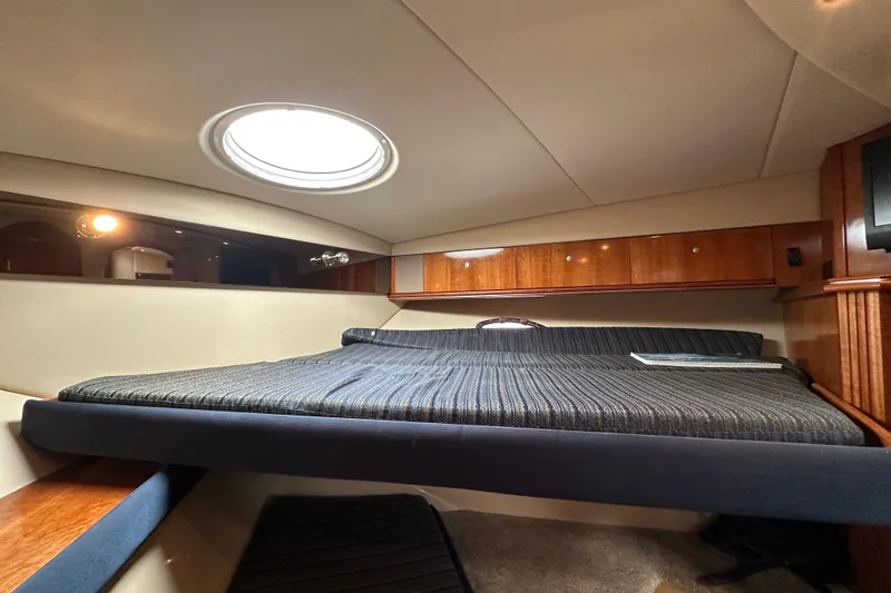 Slide: The Image of 2005 Cruisers Yachts 440 Express cabin interior with bed and porthole window. - 35