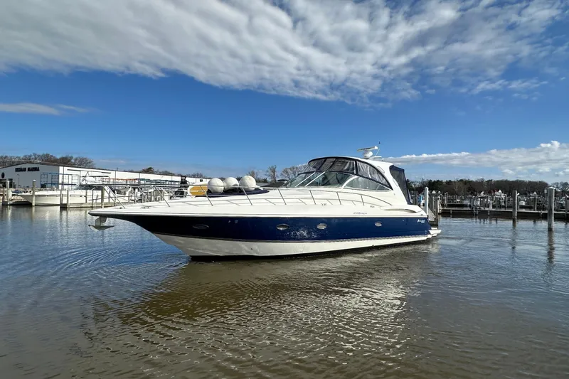 Slide: The Image of 2005 Cruisers Yachts 440 Express in marina, blue and white hull, clear sky. - 9