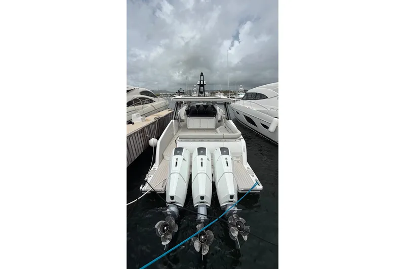 Slide: The Image of 2024 Azimut Verve 48 yacht docked, featuring triple outboard engines, under cloudy skies. - 20