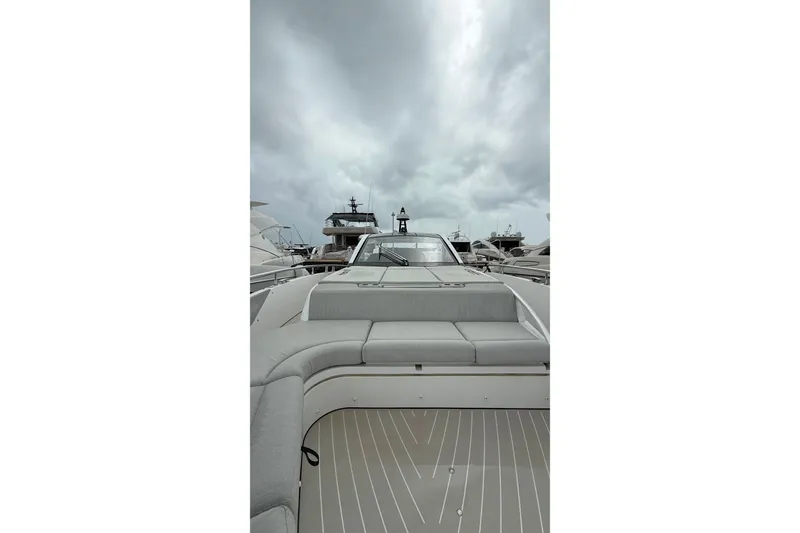 Slide: The Image of 2024 Azimut Verve 48 yacht with sleek design and luxurious seating under cloudy skies. - 16