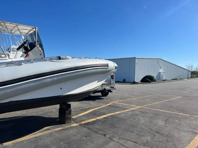 Slide: The Image of 2023 Zodiac N-ZO 680 boat on trailer in parking lot, clear blue sky. - 6