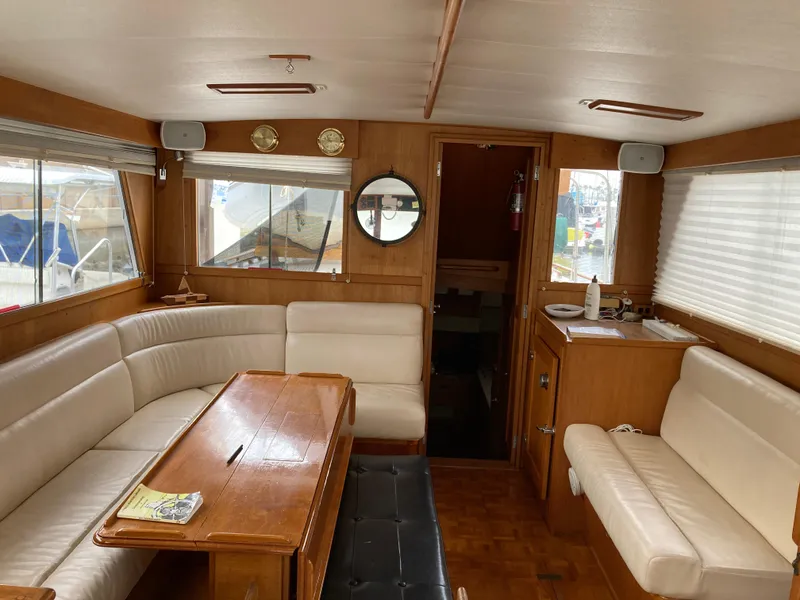 Slide: The Image of Interior of 1985 Grand Banks 42 Classic yacht with wood paneling and cream seating. - 16