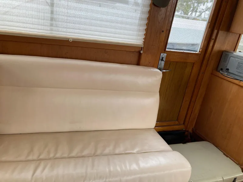 Slide: The Image of Interior of 1985 Grand Banks 42 Classic with white leather seating and wooden paneling. - 20