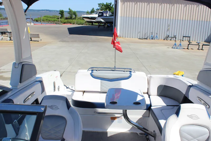 Slide: The Image of 2020 Chaparral 277 SSX boat interior with seating and table, docked near water. - 19
