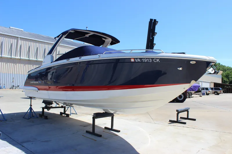 Slide: The Image of 2020 Chaparral 277 SSX boat on stands, blue and white hull, outdoor setting. - 4