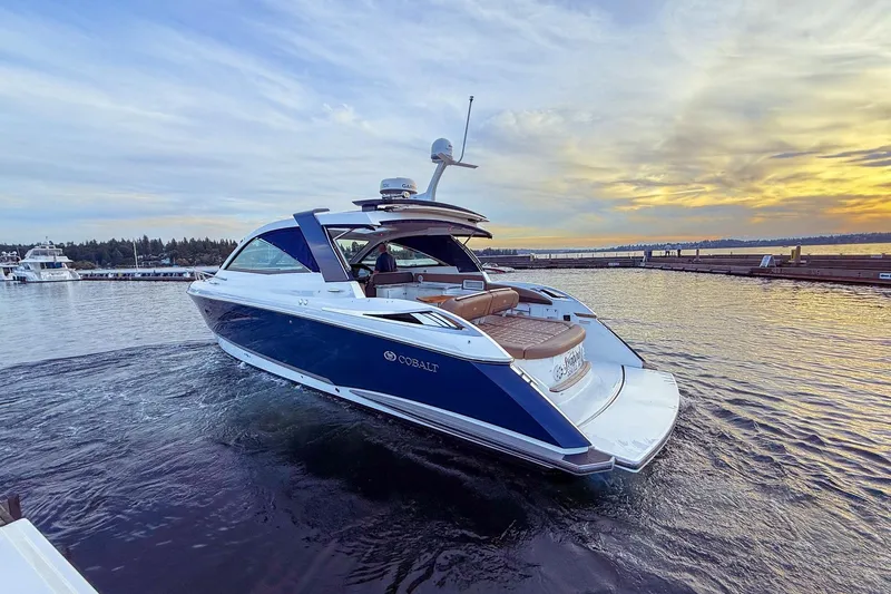 Slide: The Image of 2017 Cobalt A40 Coupe luxury boat cruising on a serene lake at sunset. - 1