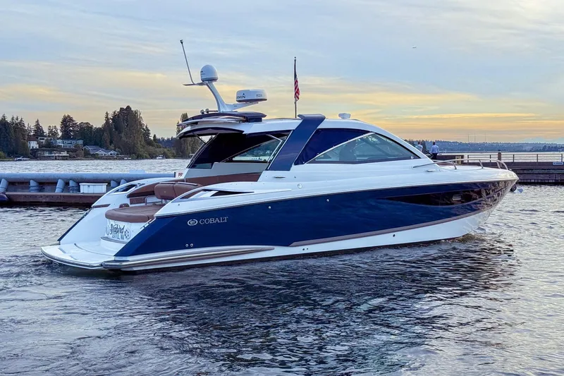 Slide: The Image of 2017 Cobalt A40 Coupe luxury boat on serene water at sunset. - 10
