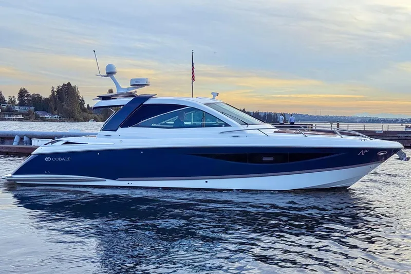 Slide: The Image of 2017 Cobalt A40 Coupe yacht on serene water at sunset, showcasing sleek design and luxury. - 14