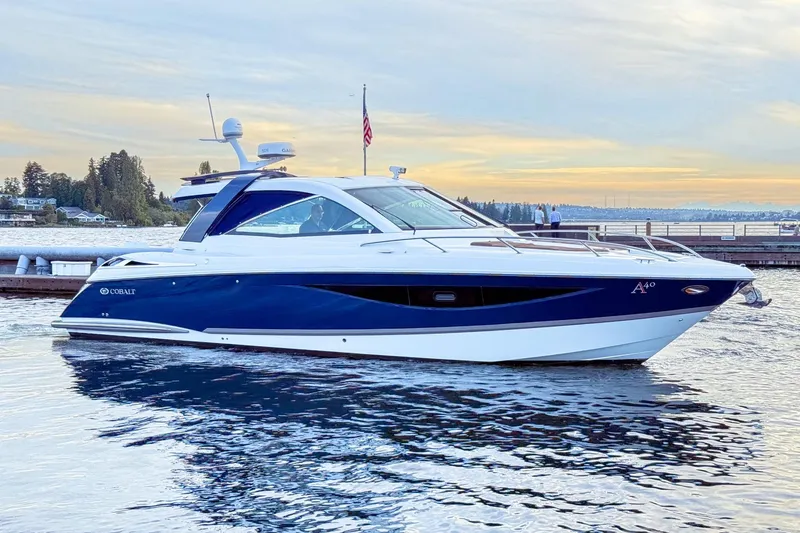 Slide: The Image of 2017 Cobalt A40 Coupe luxury boat docked on serene water at sunset. - 15