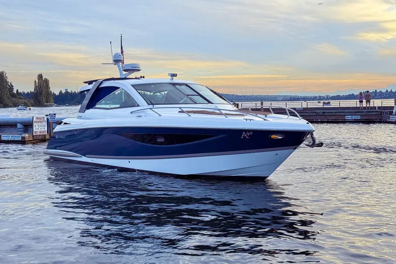 Slide: The Image of 2017 Cobalt A40 Coupe boat on water at sunset near dock. - 18