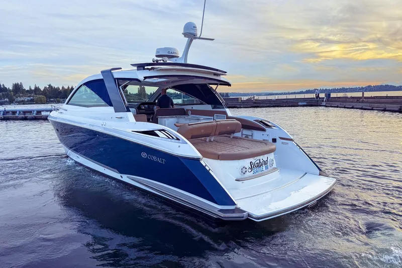 Slide: The Image of 2017 Cobalt A40 Coupe boat cruising on a serene lake at sunset. - 2