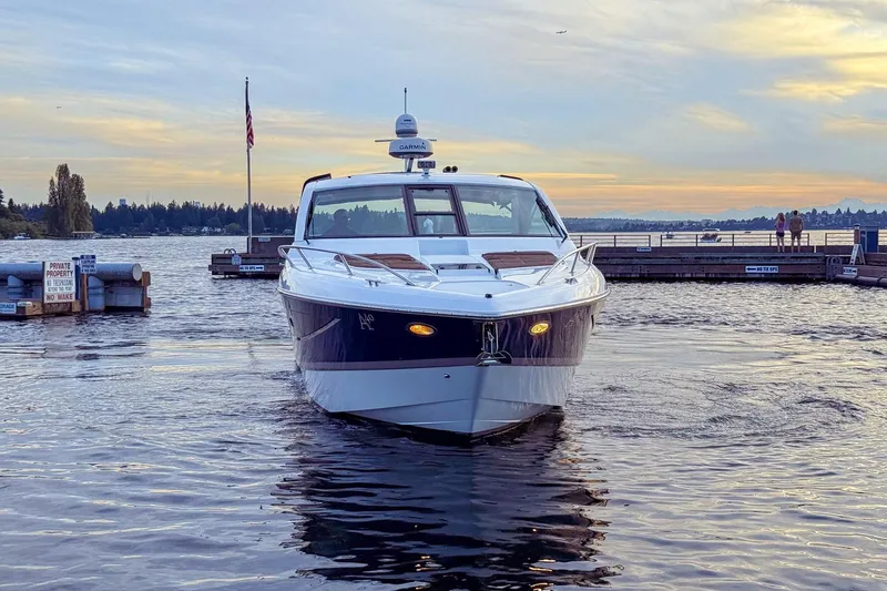 Slide: The Image of 2017 Cobalt A40 Coupe boat docked at sunset with scenic waterfront view. - 20