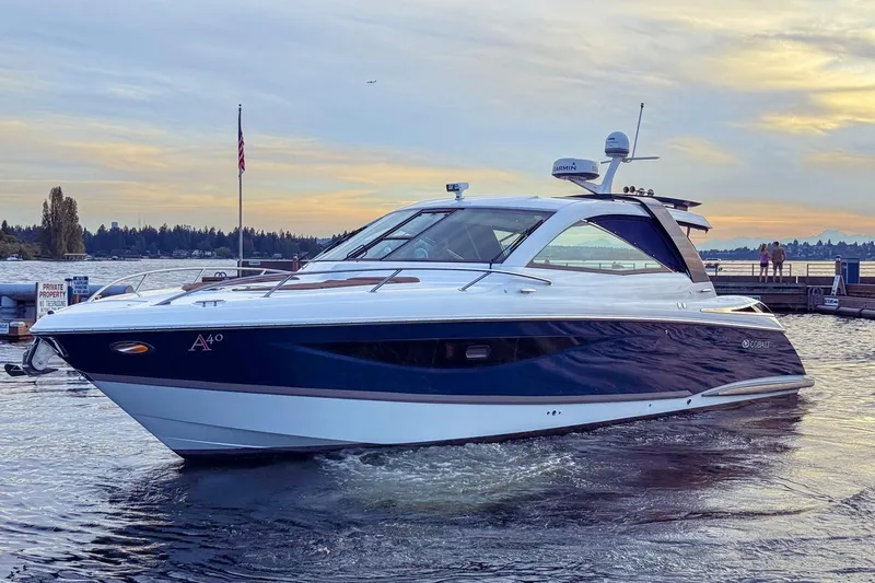 Slide: The Image of 2017 Cobalt A40 Coupe yacht on serene water at sunset. - 24