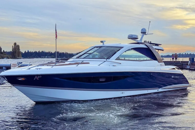 Slide: The Image of 2017 Cobalt A40 Coupe yacht on serene water at sunset. - 25