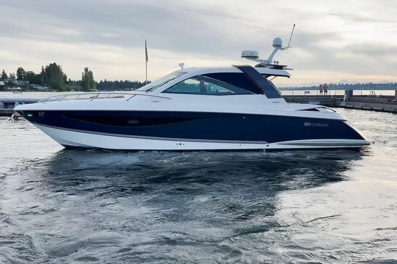 Slide: The Image of 2017 Cobalt A40 Coupe luxury boat docked on calm water at sunset. - 28
