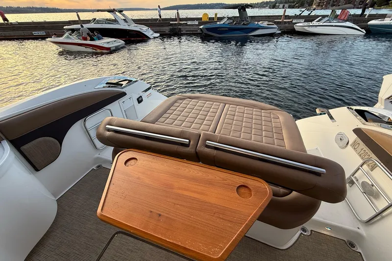 Slide: The Image of 2017 Cobalt A40 Coupe boat interior with luxurious seating and wooden table by the water. - 29