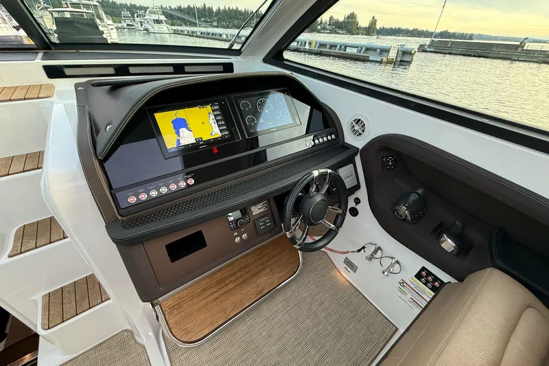 Slide: The Image of 2017 Cobalt A40 Coupe helm with navigation display, steering wheel, and waterfront view. - 36