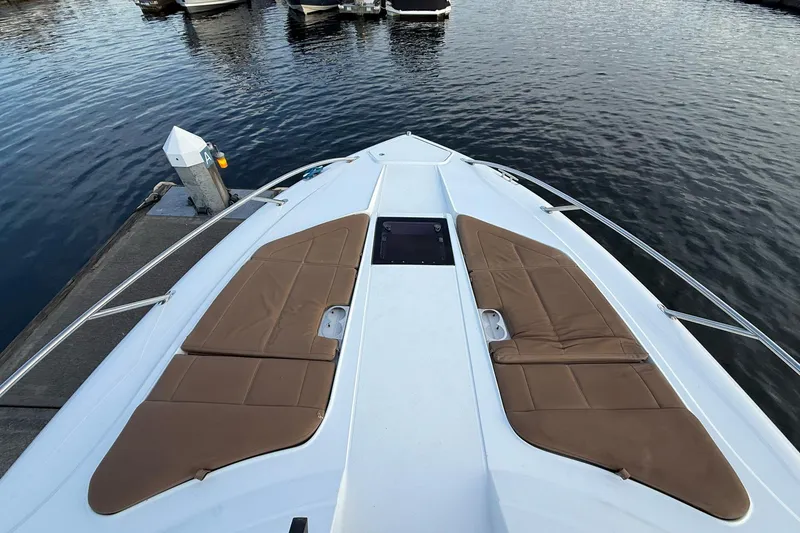 Slide: The Image of 2017 Cobalt A40 Coupe boat bow with tan cushions docked at marina. - 49