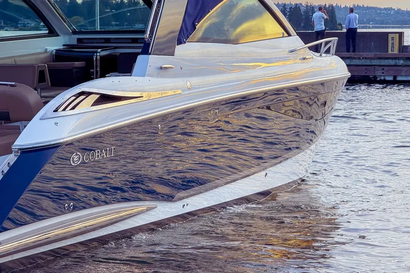 Slide: The Image of 2017 Cobalt A40 Coupe luxury boat docked on calm water at sunset. - 8