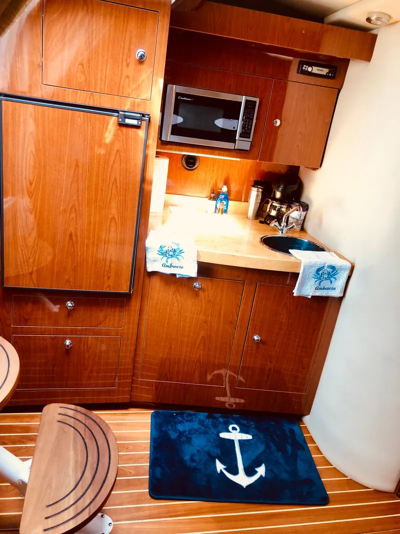 Slide: The Image of Interior of 2009 Regal Commodore 3760 IO yacht, featuring wood-paneled kitchen. - 17