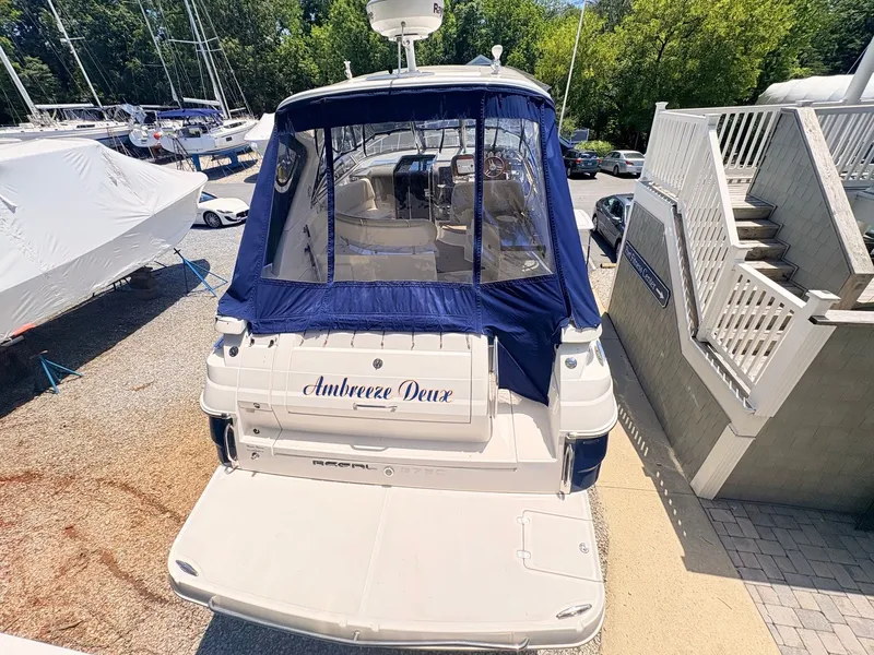 Slide: The Image of Rear view of a Regal Commodore 3760 IO with blue cover, in a boat storage area. - 30