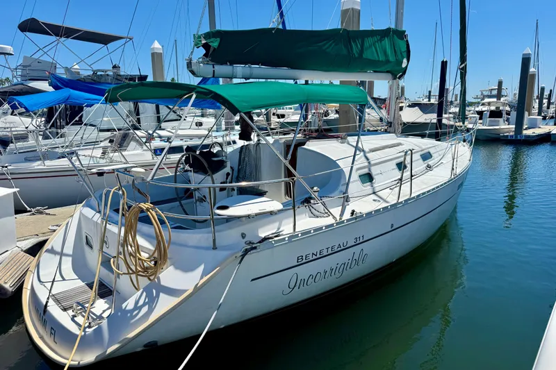 Slide: The Image of 2002 Beneteau Oceanis Clipper 311 sailboat docked in marina, green canopy, sunny day. - 2