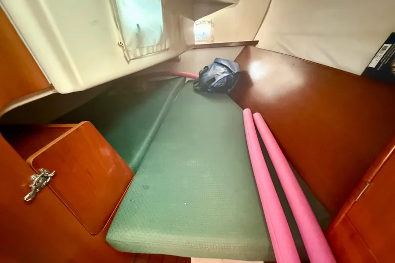 Slide: The Image of Interior cabin of 2002 Beneteau Oceanis Clipper 311 sailboat with green cushion and storage. - 25