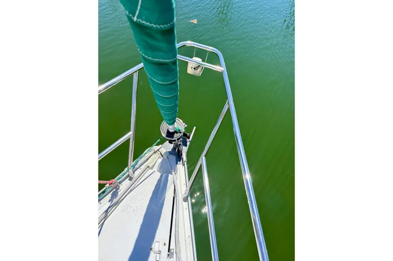 Slide: The Image of Bow view of 2002 Beneteau Oceanis Clipper 311 sailboat on calm green water. - 8