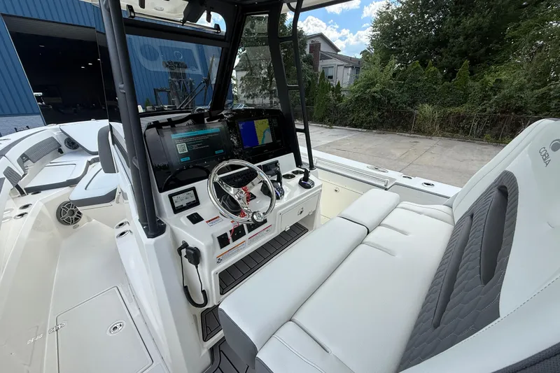Slide: The Image of 2026 Cobia 305 Center Console boat interior with modern dashboard and seating. - 14