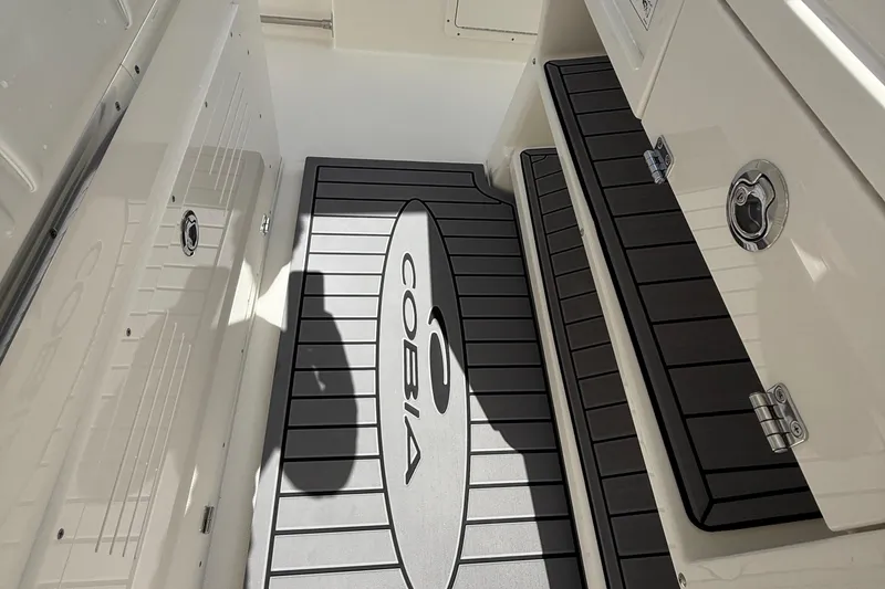 Slide: The Image of 2026 Cobia 305 Center Console boat interior with branded flooring and storage compartments. - 31
