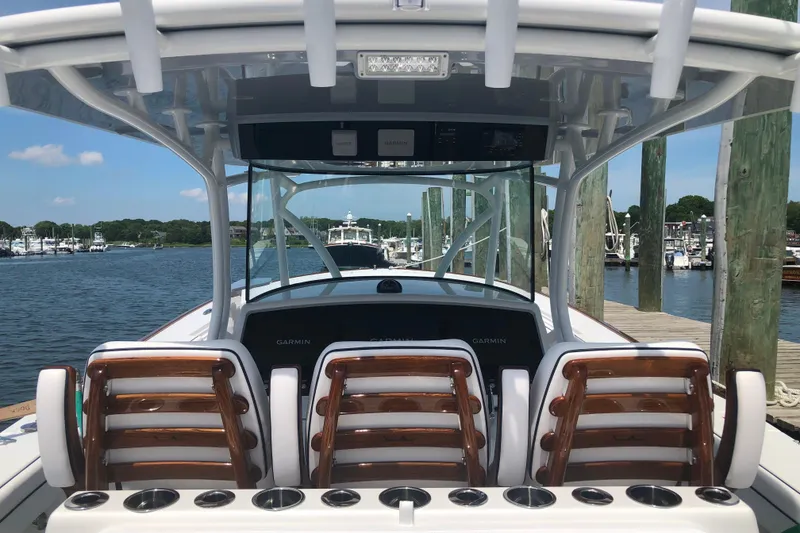 Slide: The Image of 2025 Valhalla Boatworks V-41 cockpit with seating and Garmin electronics at a marina. - 10