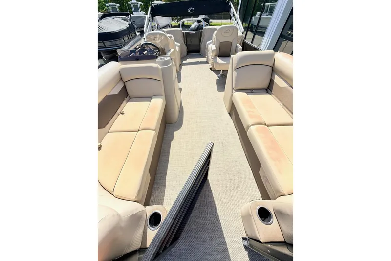 Slide: The Image of 2021 Crest Classic DLX 220 SLC pontoon boat interior with beige seating and cup holders. - 10