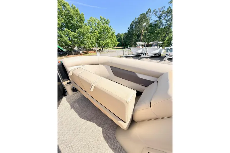 Slide: The Image of 2021 Crest Classic DLX 220 SLC boat interior with beige seating and cup holder. - 12