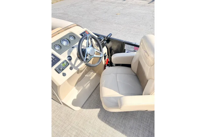 Slide: The Image of 2021 Crest Classic DLX 220 SLC boat helm with beige captain's chair and steering wheel. - 13