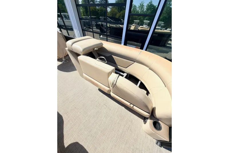 Slide: The Image of 2021 Crest Classic DLX 220 SLC boat interior with beige seating and cup holders. - 6