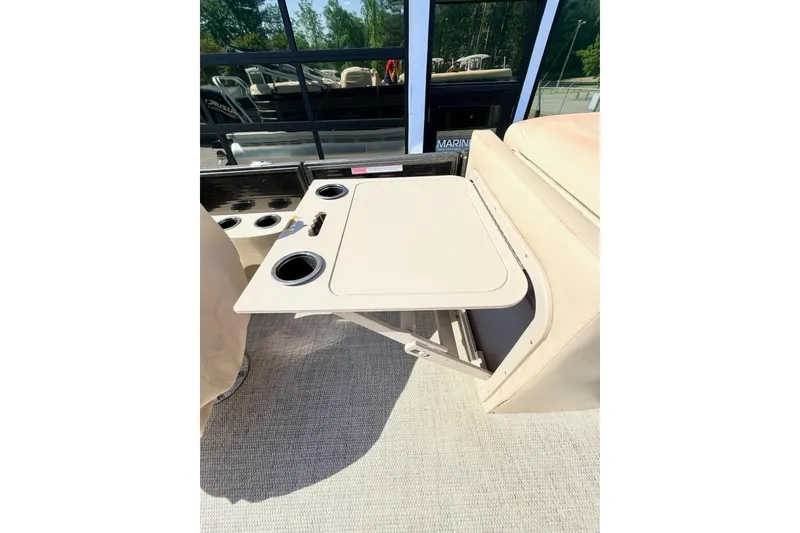 Slide: The Image of 2021 Crest Classic DLX 220 SLC boat interior with foldable table and cup holders. - 7