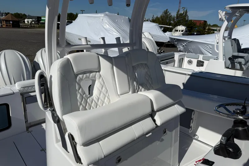 Slide: The Image of 2026 Sportsman Open 302 Center Console boat interior with white seating and steering wheel. - 11
