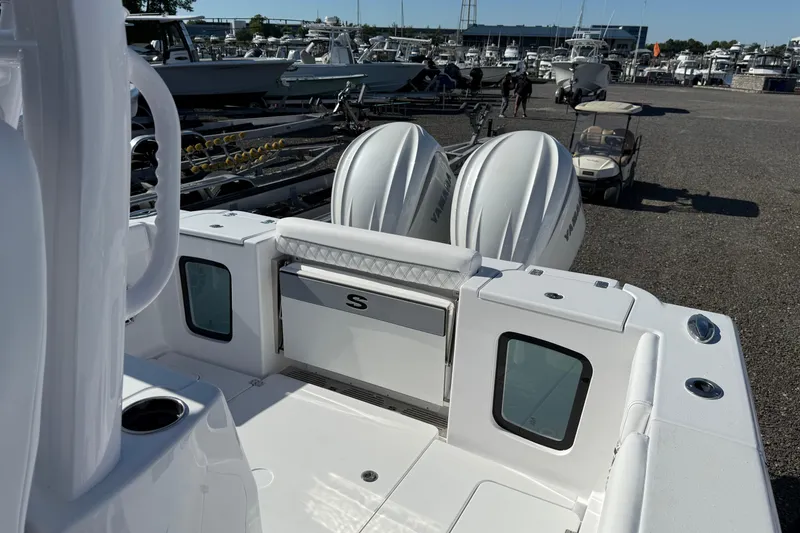 Slide: The Image of 2026 Sportsman Open 302 Center Console boat with dual Yamaha engines at a marina. - 13
