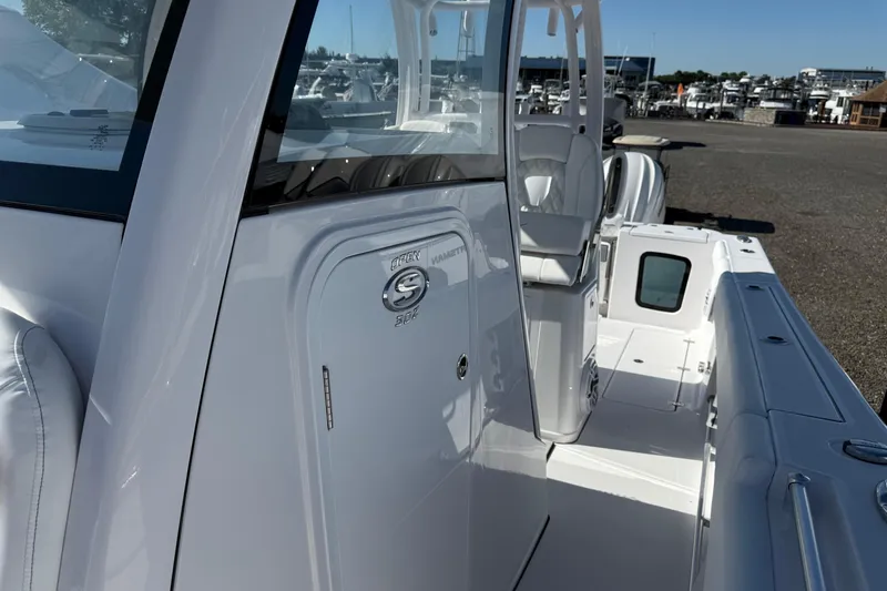 Slide: The Image of 2026 Sportsman Open 302 Center Console boat, sleek design, docked at marina. - 6