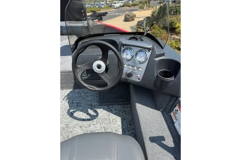 Slide: The Image of 2026 Tracker Pro Guide V-16 SC boat dashboard with steering wheel and gauges. - 8