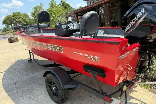 Slide: The Image of 2026 Tracker Pro Guide V-16 SC boat in red, parked on a trailer. - 2