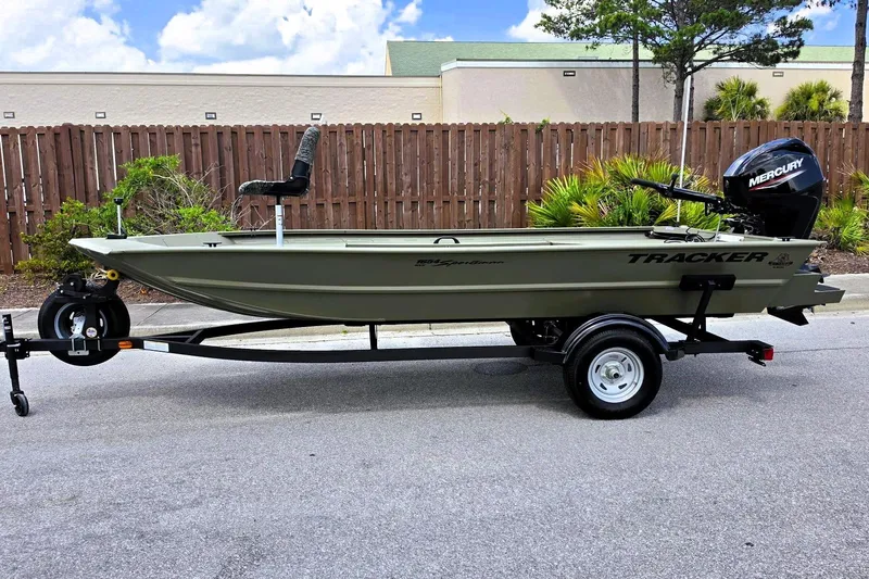 Slide: The Image of 2026 Tracker Grizzly 1654 T Sportsman boat on trailer, parked outdoors. - 8