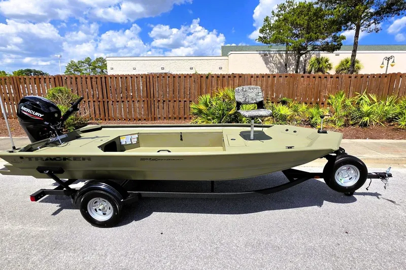 Slide: The Image of 2026 Tracker Grizzly 1654 T Sportsman boat on trailer, outdoors under blue sky. - 6