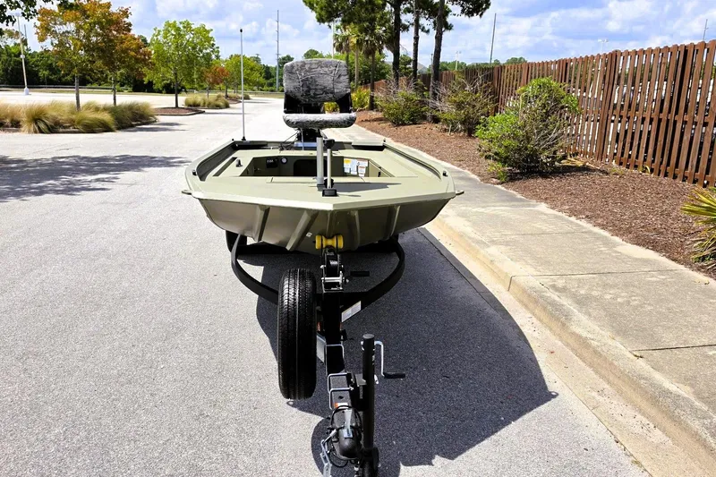 Slide: The Image of 2026 Tracker Grizzly 1654 T Sportsman boat on trailer, parked on a sunny street. - 11