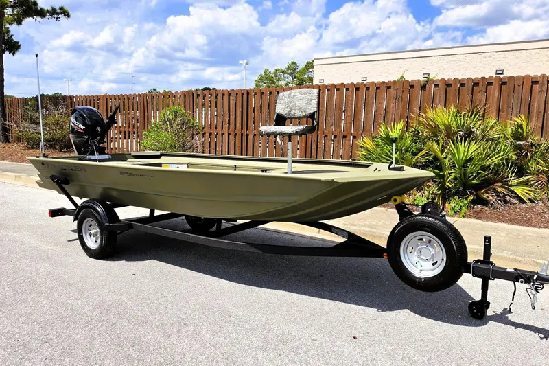 Slide: The Image of 2026 Tracker Grizzly 1654 T Sportsman boat on trailer, parked outdoors under blue sky. - 5