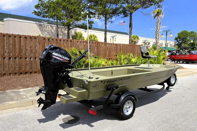 Slide: The Image of 2026 Tracker Grizzly 1654 T Sportsman boat with Mercury engine on trailer, outdoors. - 2